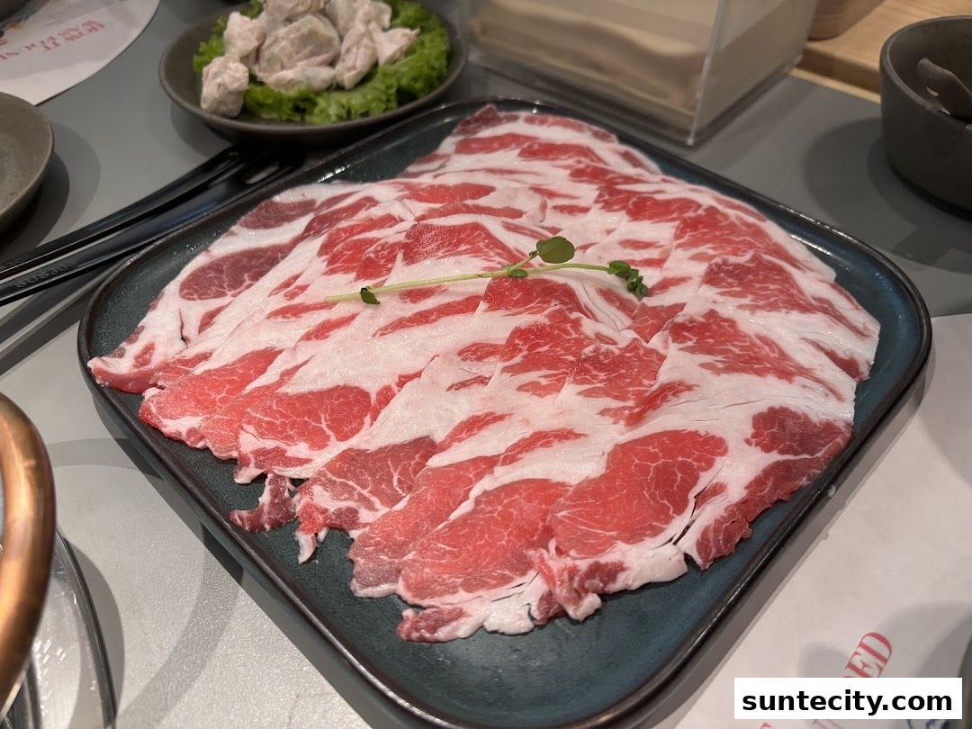A plate of thinly sliced raw beef with marbling, ready for hotpot.