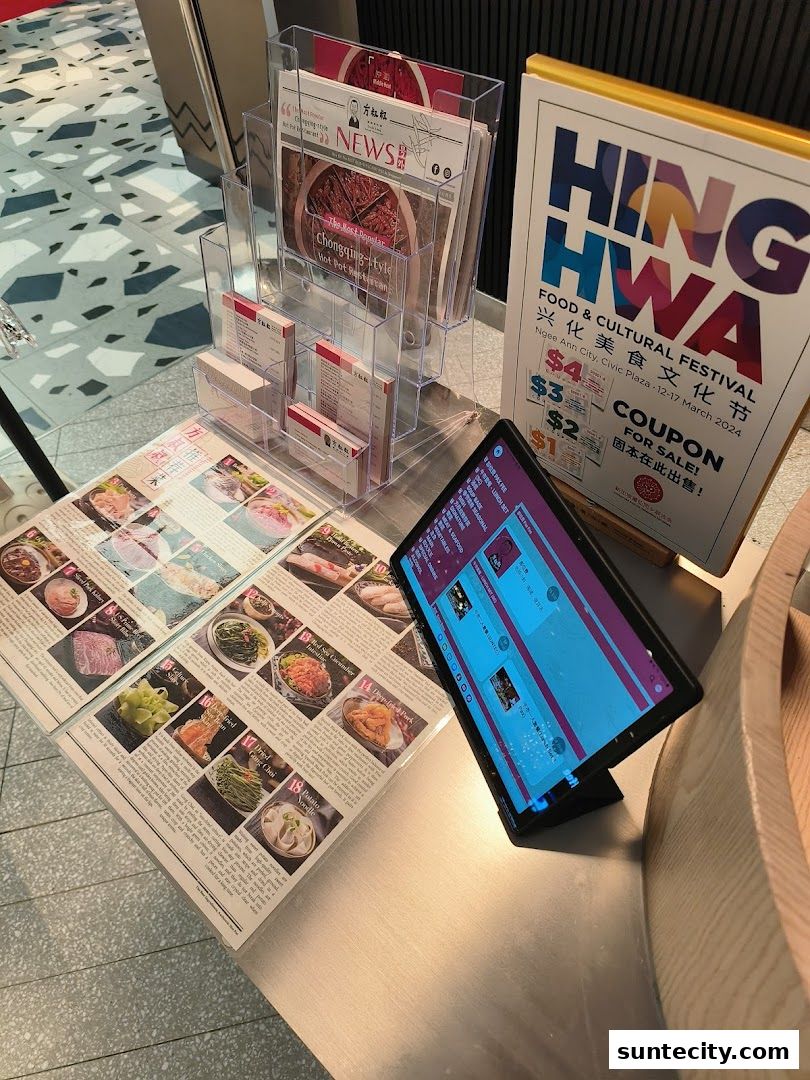 A display of menus, brochures, and a tablet promoting a food and cultural festival.