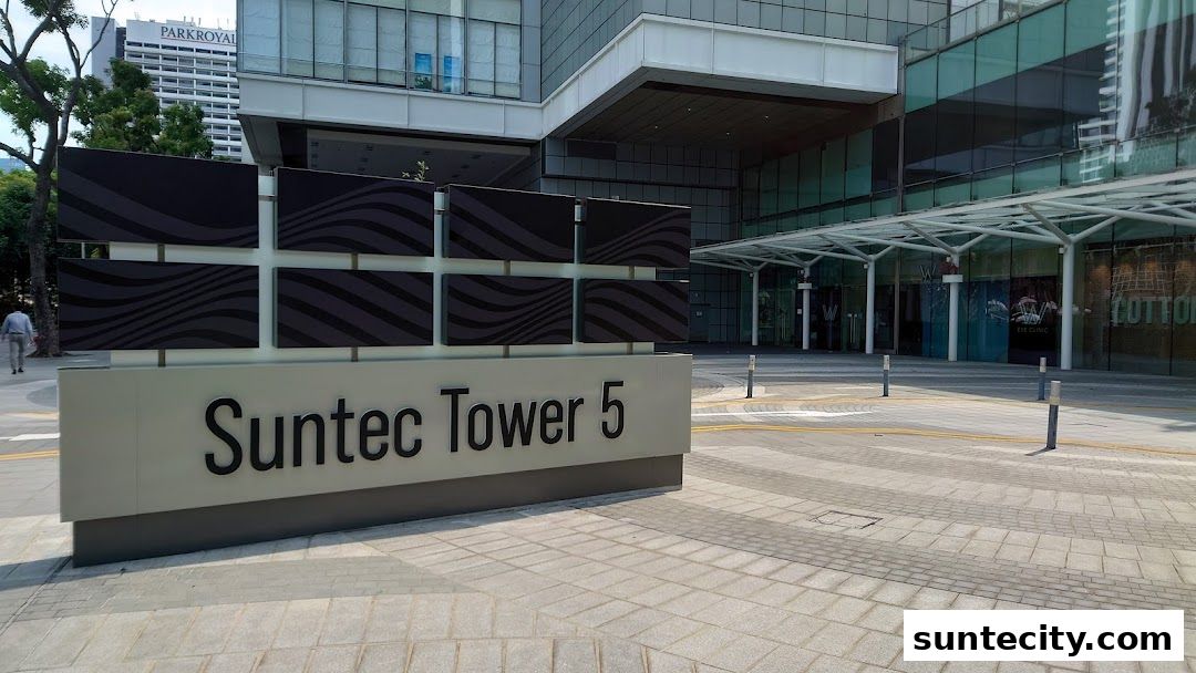 Exterior view of Suntec Tower 5 with shops and a sign.