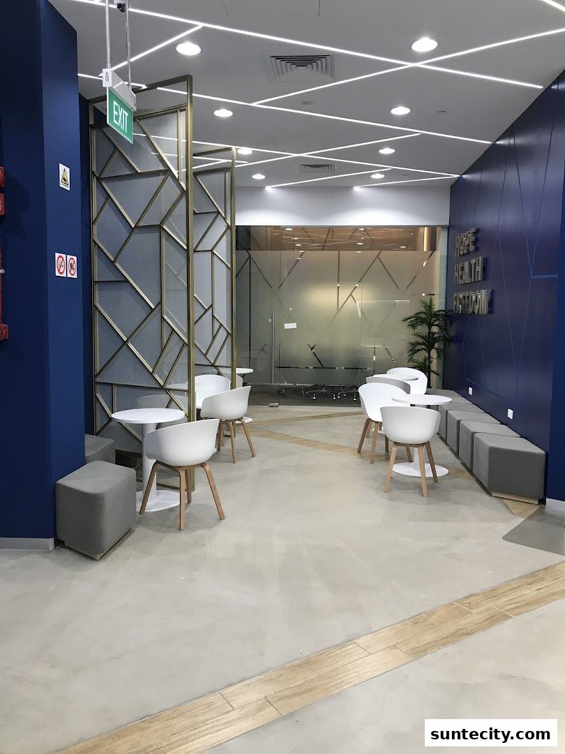 Modern seating area with white chairs and tables, featuring decorative screens and blue walls.