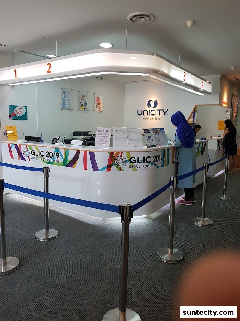 The Unicity shop front with a counter, signage, and queuing barriers.