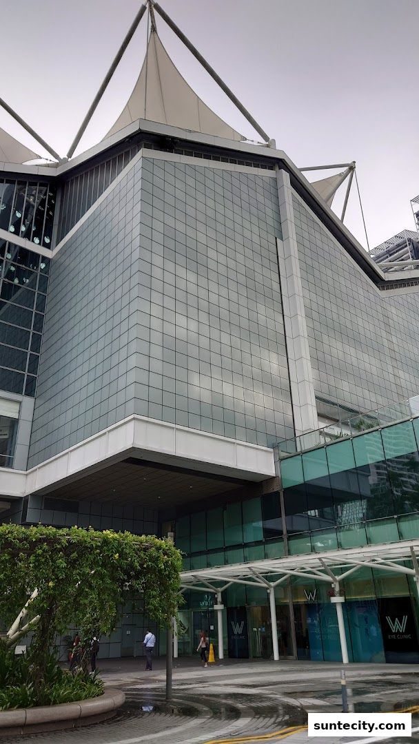 The modern glass facade of a building with the 'W Eye Clinic' entrance visible.