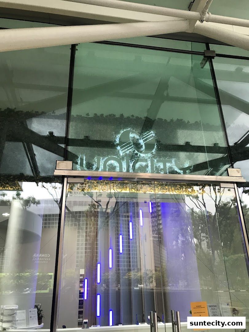 The Unicity shop front features a modern glass facade with a neon logo and decorative lighting.