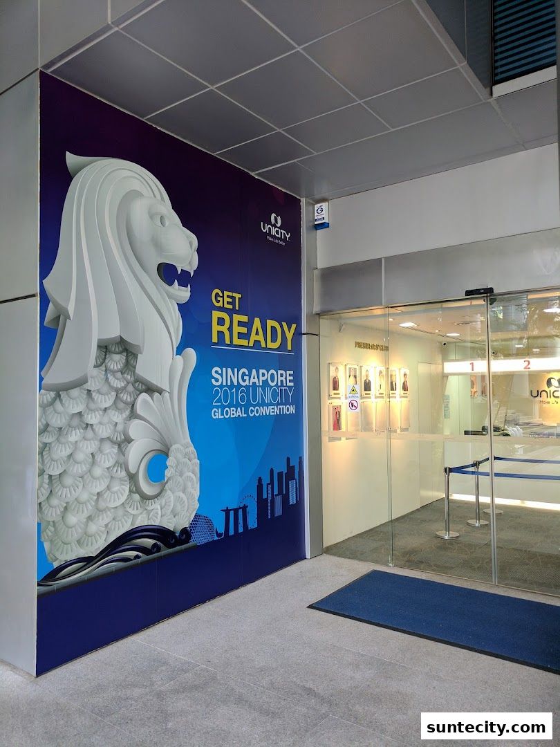 The entrance to Unicity, featuring a large mural of the Merlion and text about a global convention.