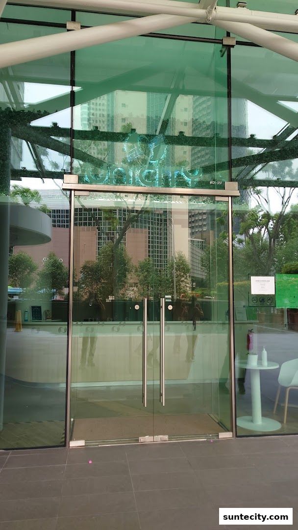 The modern glass entrance of the Unicity shop with its illuminated logo.