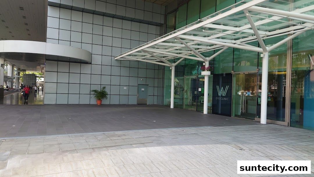 The modern entrance of a W Eye Clinic with glass doors and a white canopy.