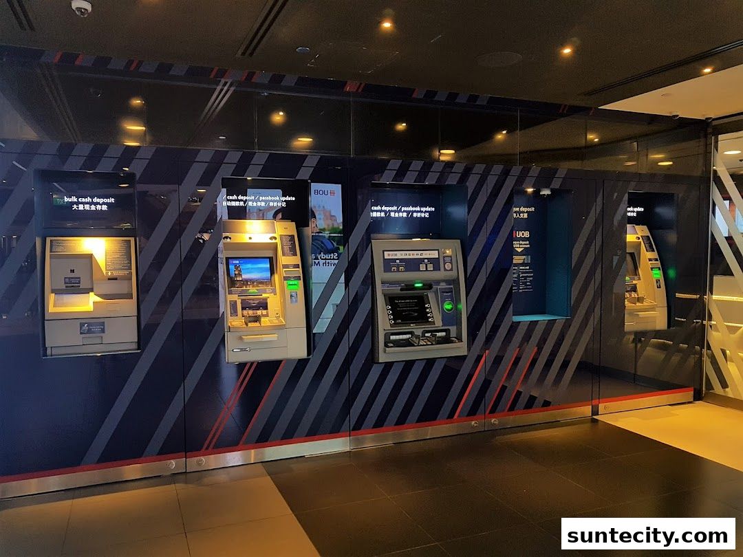 Multiple UOB ATMs are lined up against a modern, dark wall with diagonal stripes.