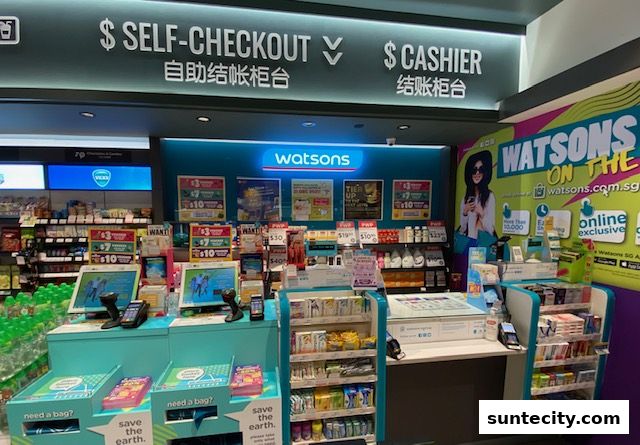 The interior of a Watsons store featuring self-checkout, cashier counters, and product displays.