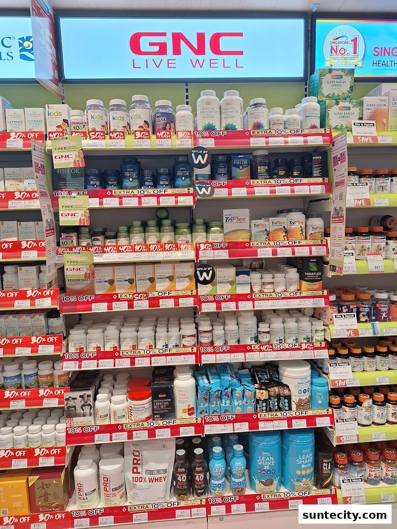 A wide selection of GNC health supplements and vitamins displayed on shelves with promotional signage.