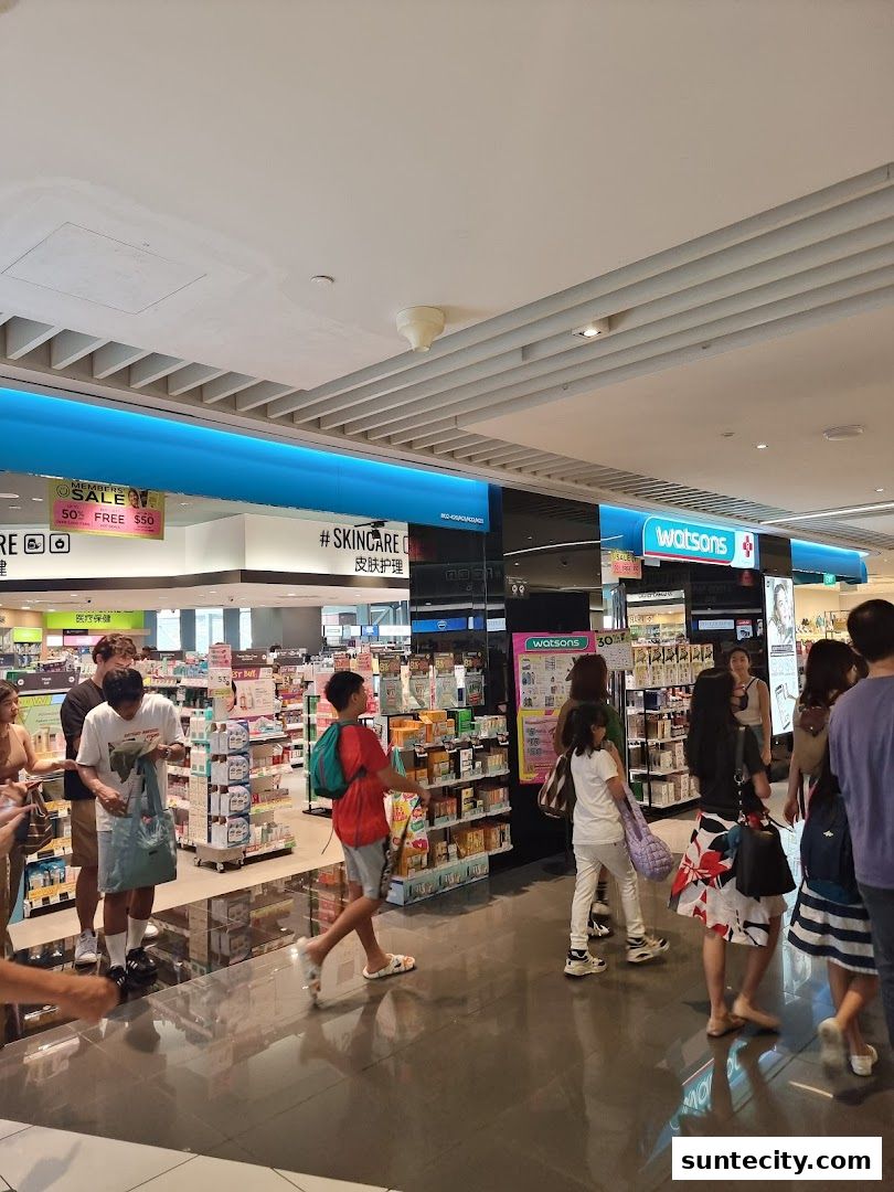 People browsing inside a Watsons pharmacy and GNC store.