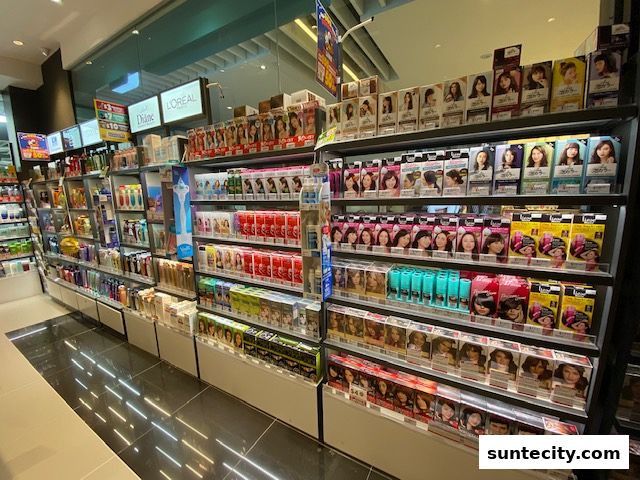 Shelves stocked with hair dye boxes and other beauty products in a retail store.