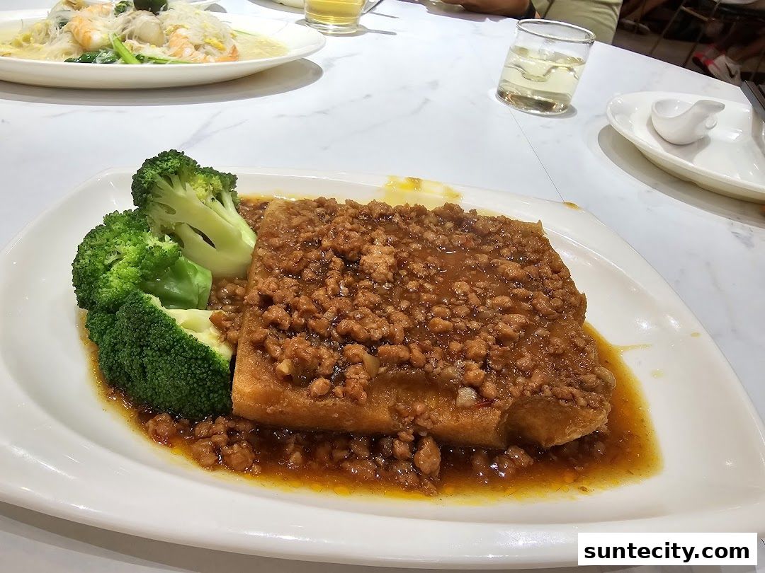 A plate of fried tofu topped with minced meat and broccoli, served at White Restaurant.