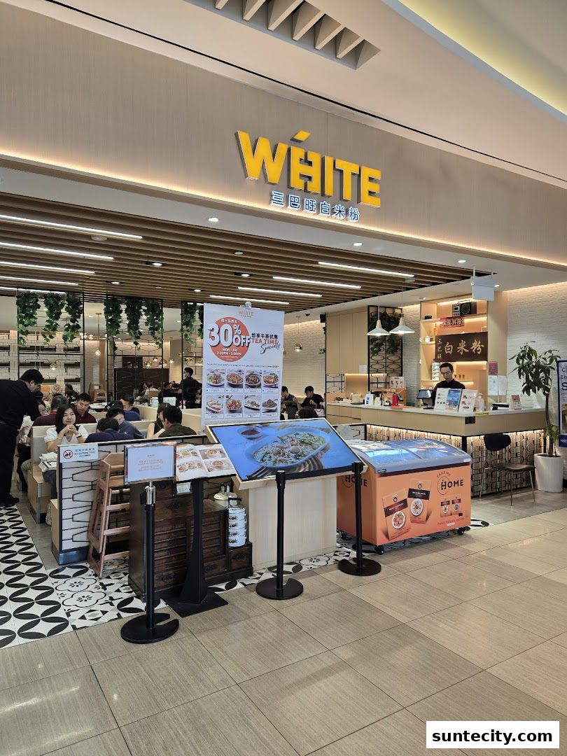 The exterior of White Restaurant Suntec City, showcasing its modern interior and a promotional poster.