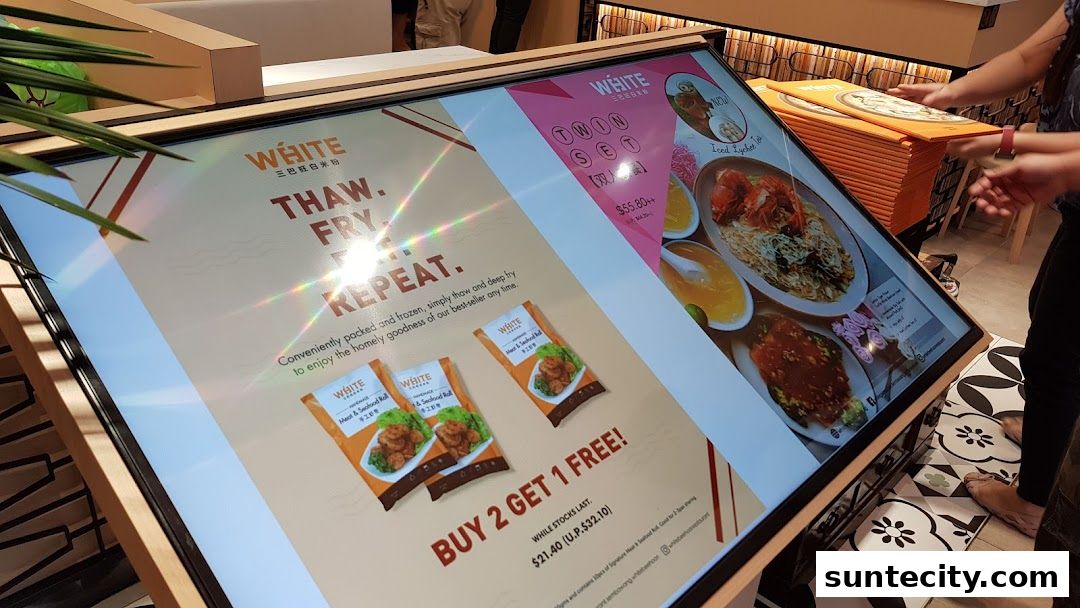 A digital menu display showcasing food items and promotions for White Restaurant.