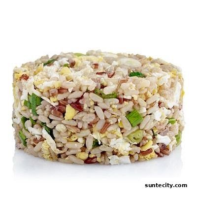 A close-up shot of a circular portion of mixed grain fried rice with egg and green onions.