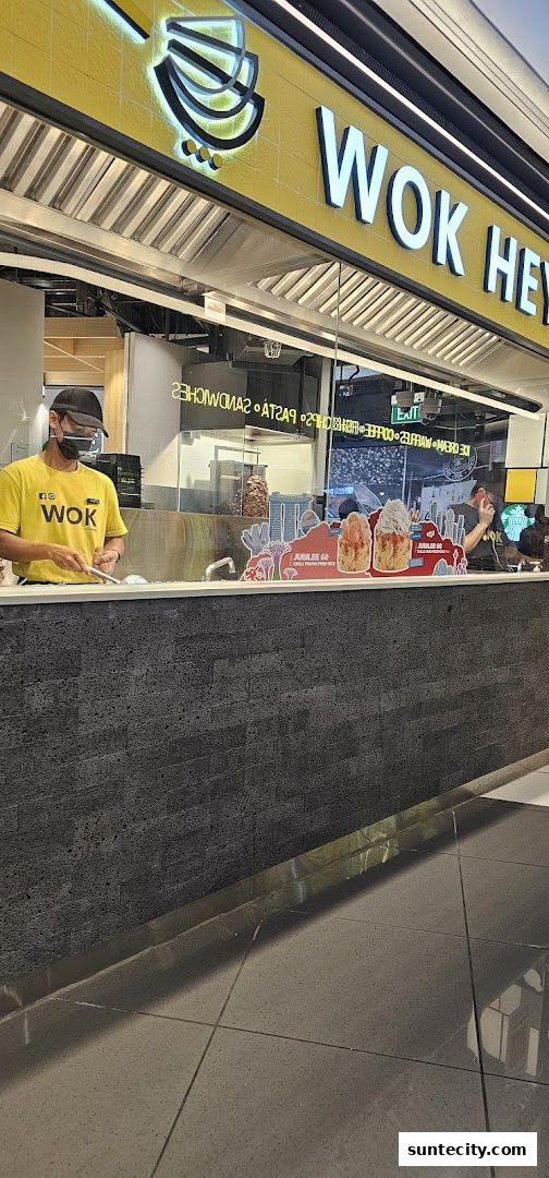 A Wok Hey stall with staff preparing food behind the counter.