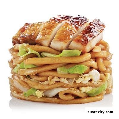 A close-up of a delicious stir-fried noodle dish topped with sliced grilled chicken.