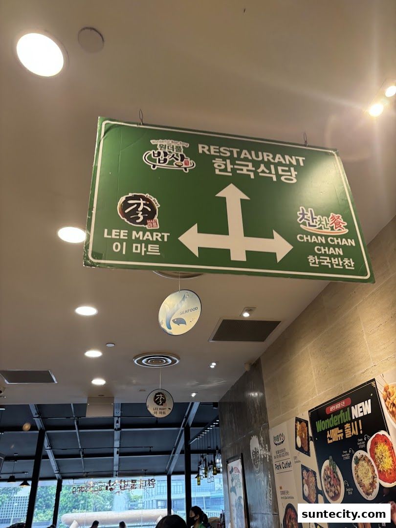 A directional sign for a Korean restaurant and market inside a building.