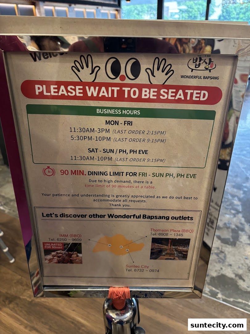 A sign for Wonderful Bapsang restaurant indicating business hours and dining limits.