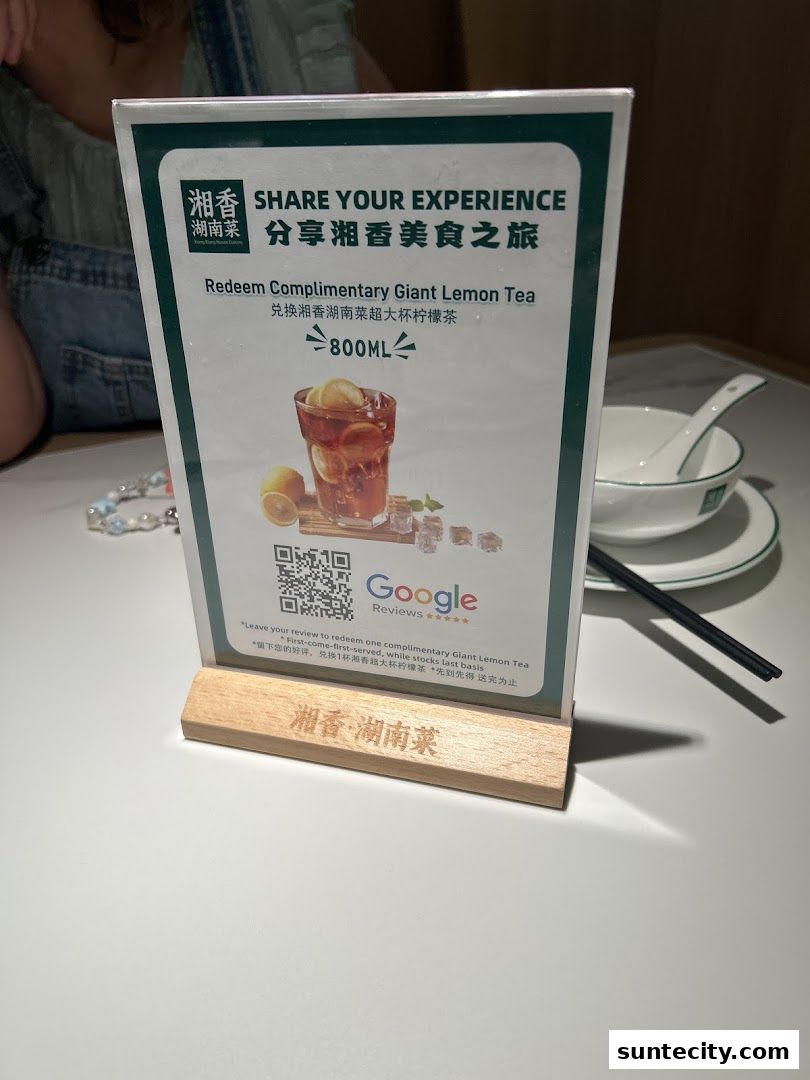 A table tent promoting a complimentary giant lemon tea with a QR code and Google reviews.