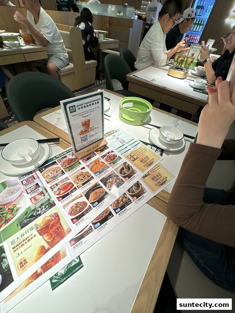 A table at Xiang Xiang Hunan Cuisine with menus and diners enjoying their meals.
