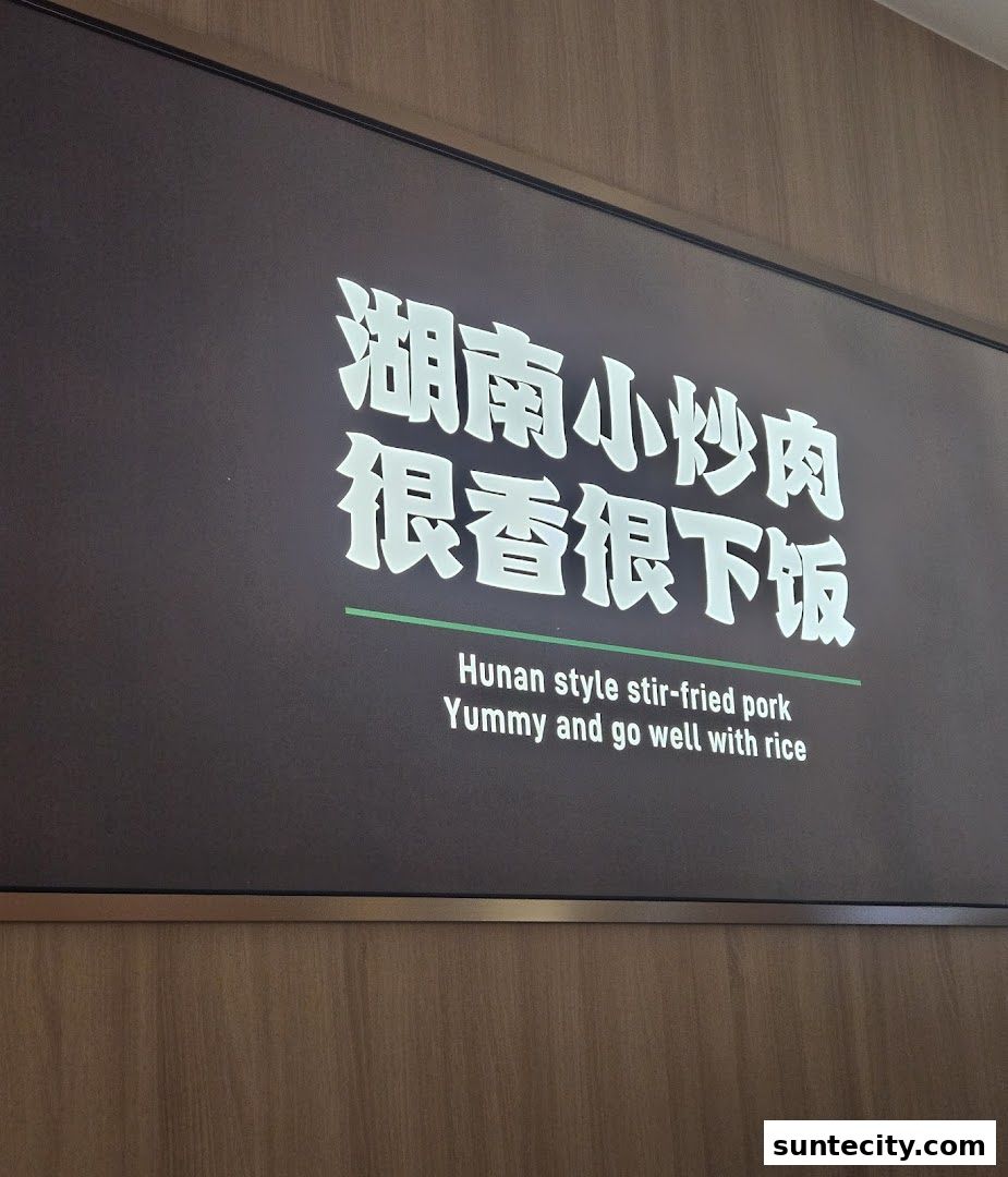 A sign displays "Hunan style stir-fried pork" in English and Chinese.