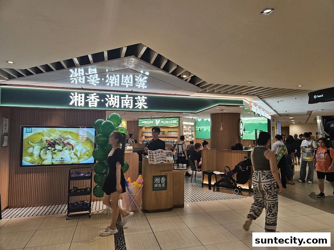 The entrance of Xiang Xiang Hunan Cuisine restaurant with a large screen displaying food.