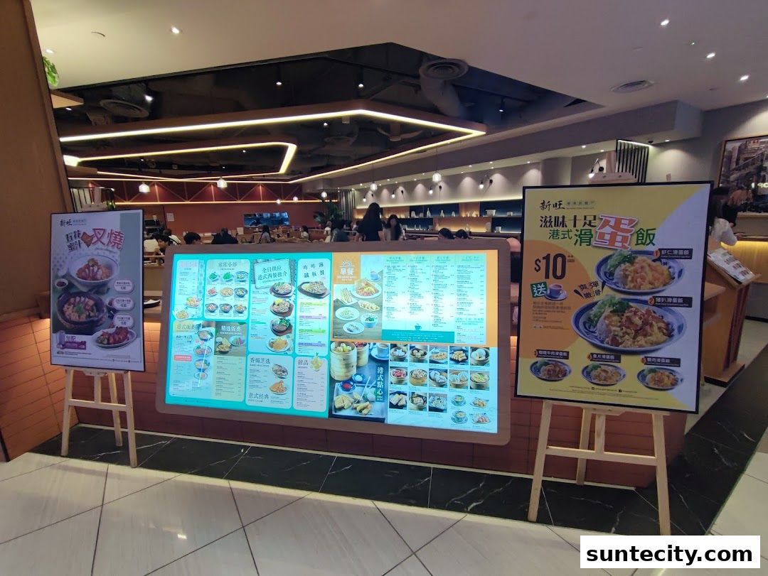 Xin Wang Hong Kong Cafe displays its menu and promotions on digital screens and posters.