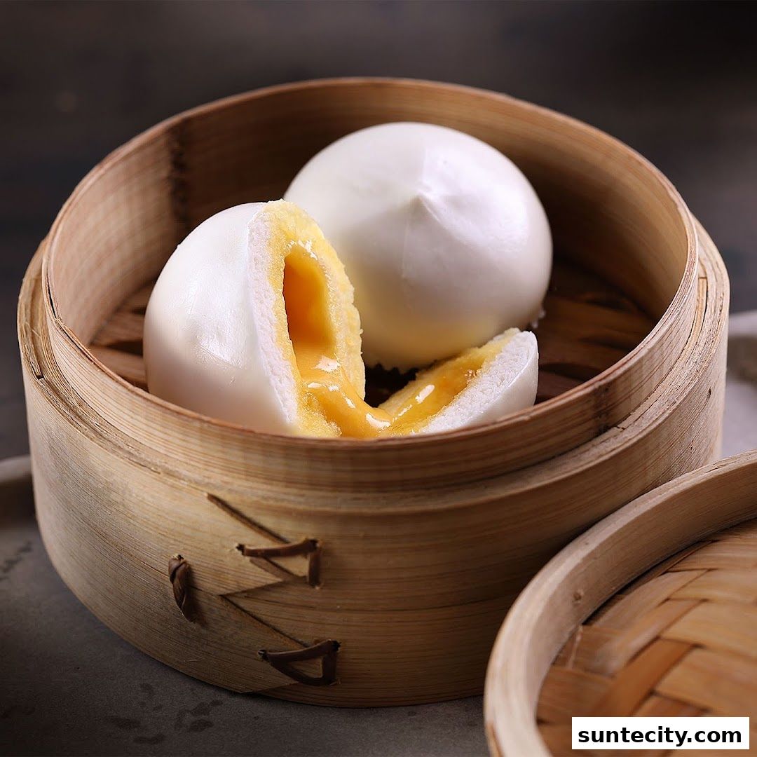 Steamed buns with a creamy yellow filling served in a bamboo steamer.