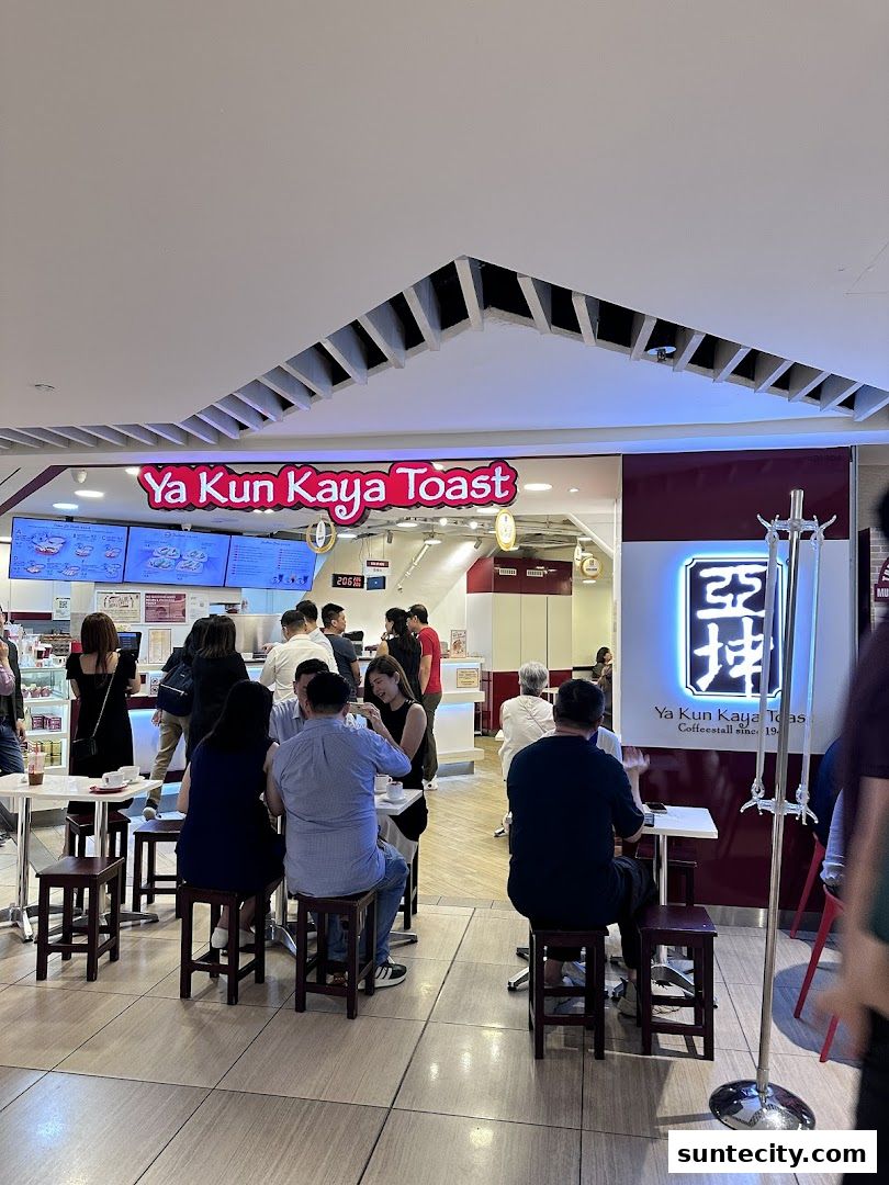 Customers are seated at tables outside Ya Kun Kaya Toast, a popular eatery.