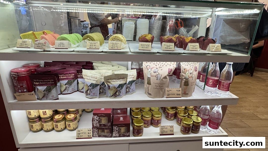 A display case filled with various pastries, cookies, coffee powder, and bottled drinks from Ya Kun Kaya Toast.