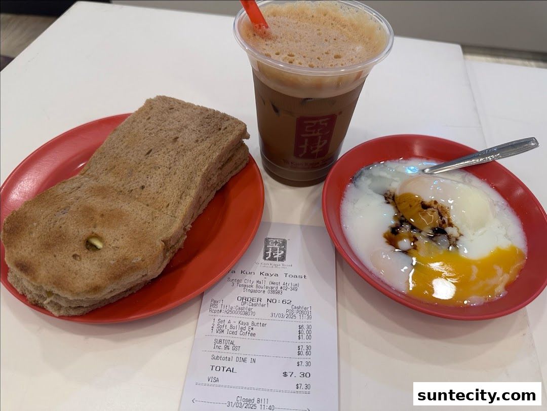 A close-up of a Ya Kun Kaya Toast meal with toast, soft-boiled eggs, and iced coffee.