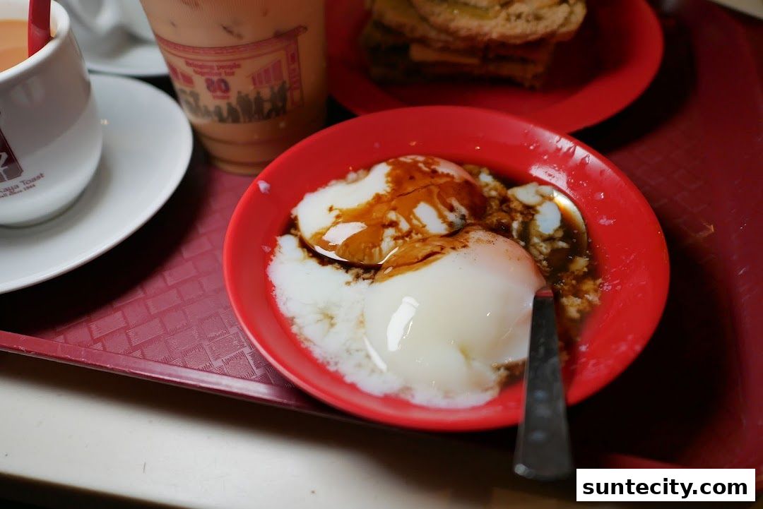 A close-up of soft-boiled eggs with soy sauce and pepper, served with coffee and toast.