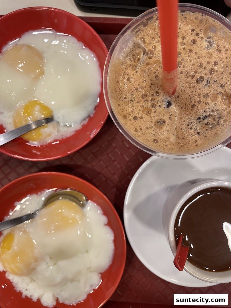 A close-up of soft-boiled eggs and a beverage at Ya Kun Kaya Toast.
