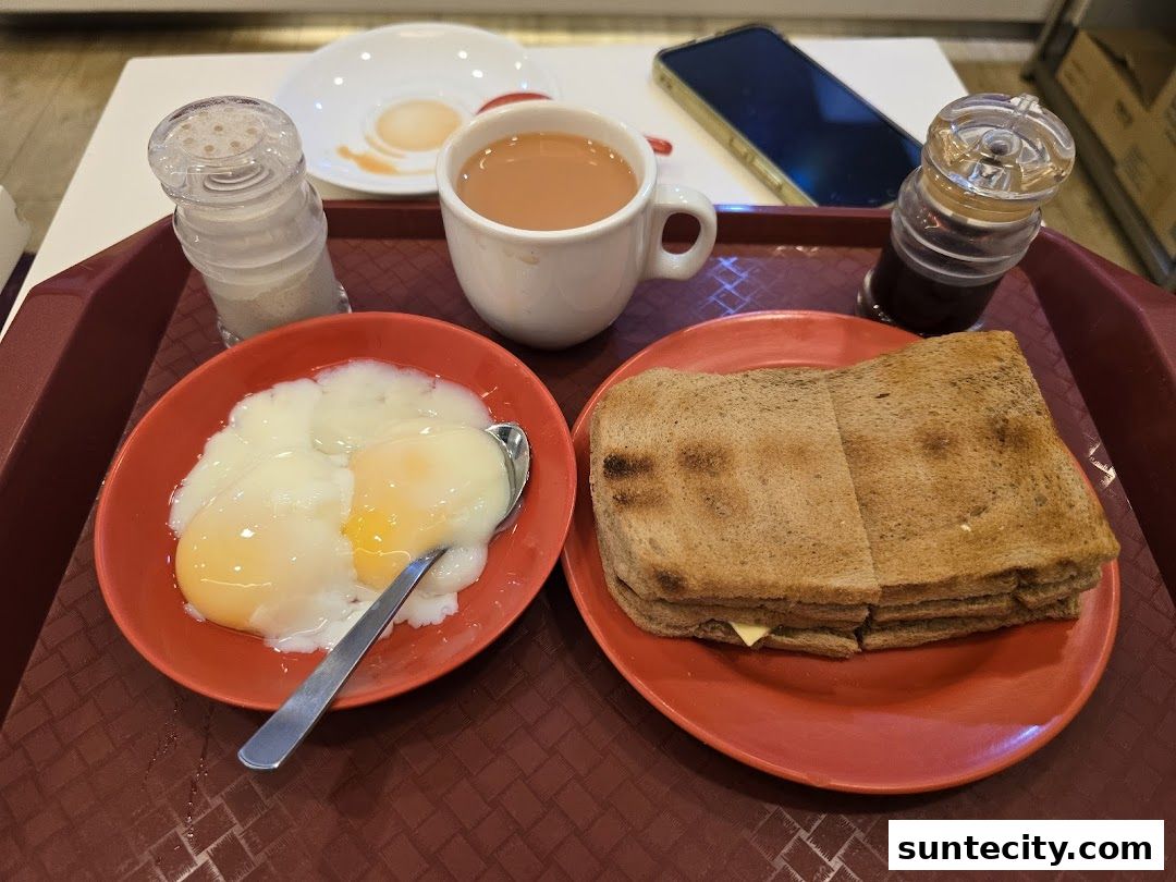 A tray with a breakfast set including soft-boiled eggs, toast, and a cup of tea.