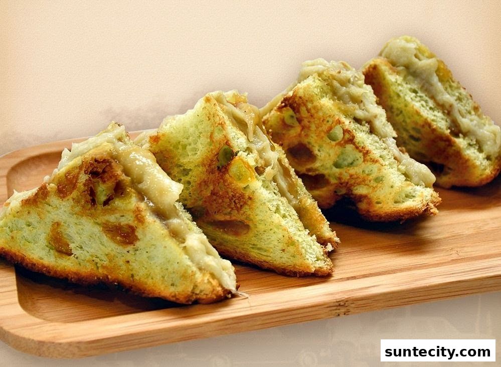 Four triangular slices of kaya toast with a creamy filling on a wooden board.