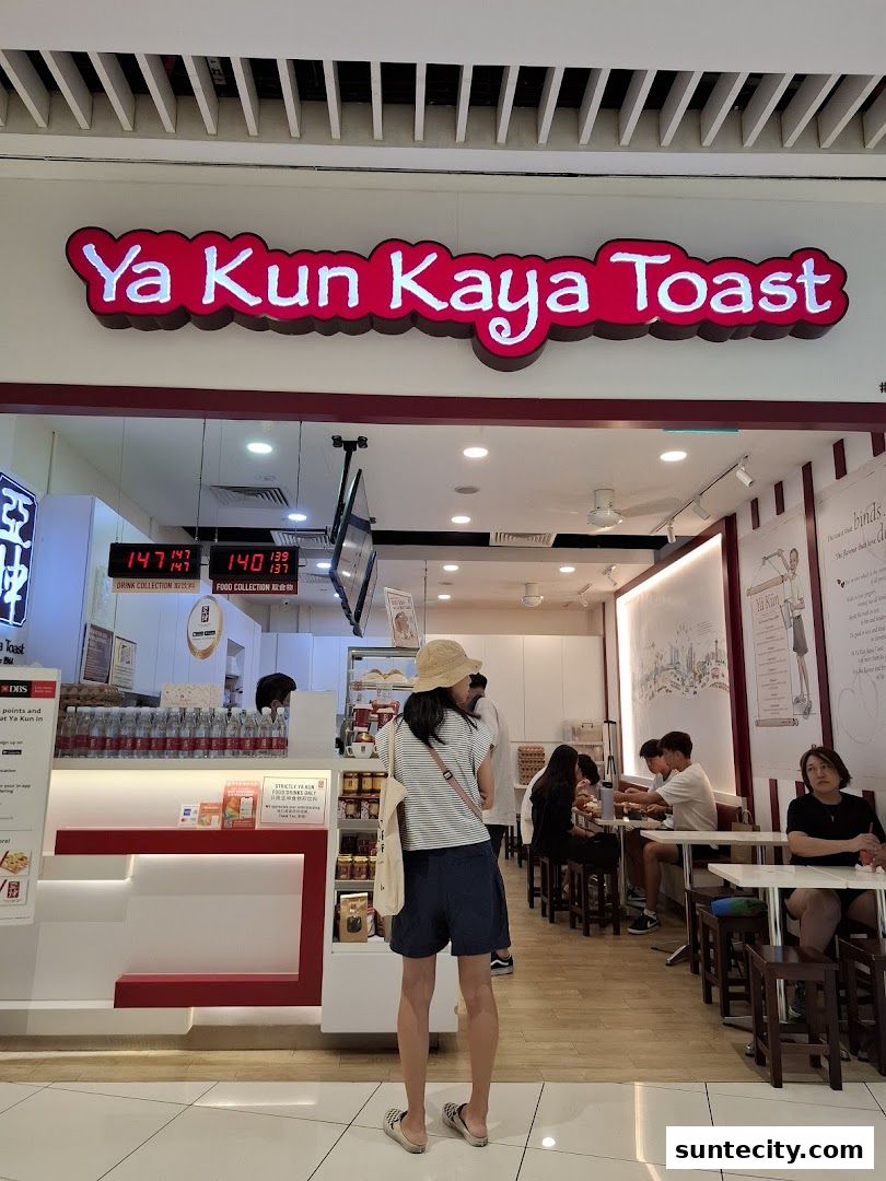 The entrance of Ya Kun Kaya Toast with customers inside and a person standing at the counter.