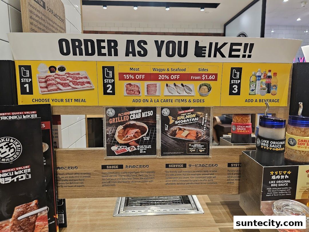A counter display at Yakiniku Like Suntec City showing ordering steps and sauces.