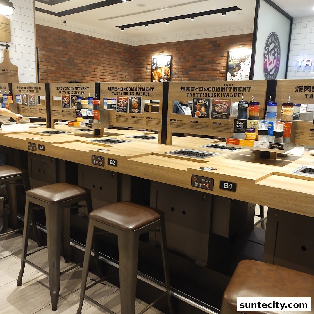 Interior view of Yakiniku Like Suntec City, showing individual grilling stations with stools.