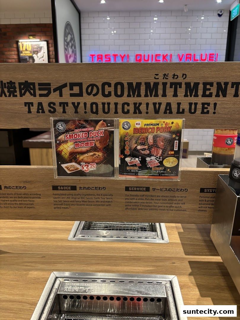 A close-up view of a Yakiniku Like restaurant counter with menu displays and grills.