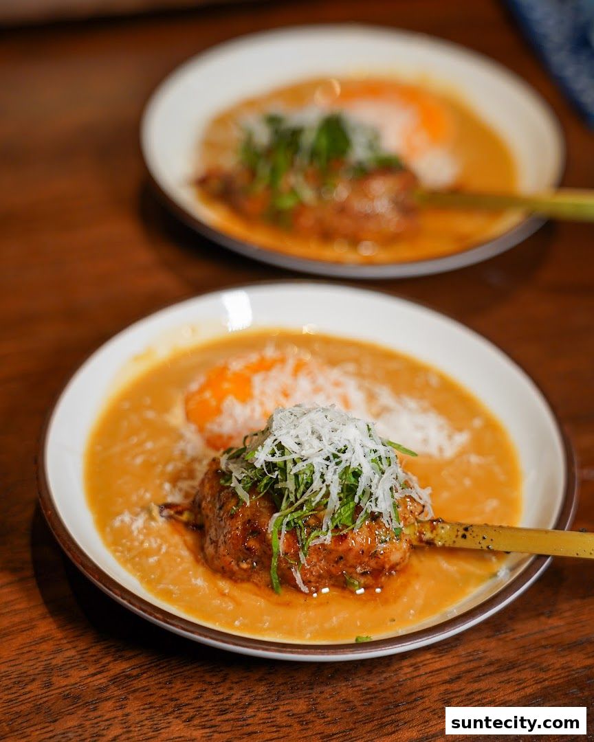 Two plates of yakitori skewers topped with shredded white ingredients and green herbs.