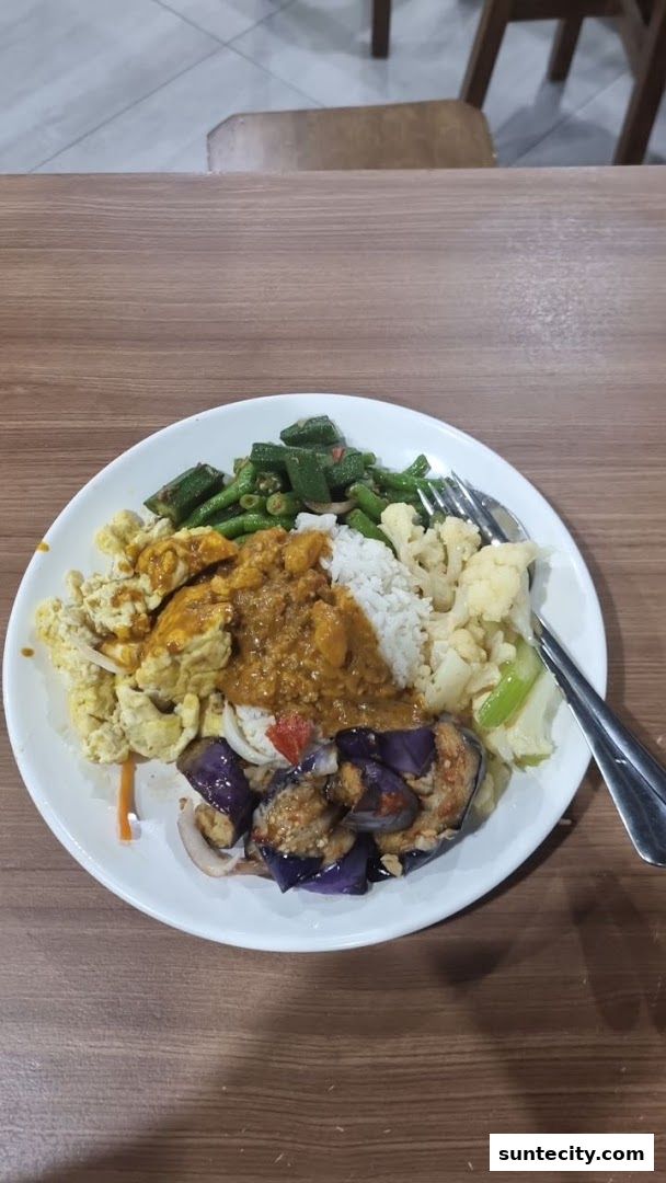 A plate of Teochew porridge with various side dishes including vegetables and scrambled eggs.