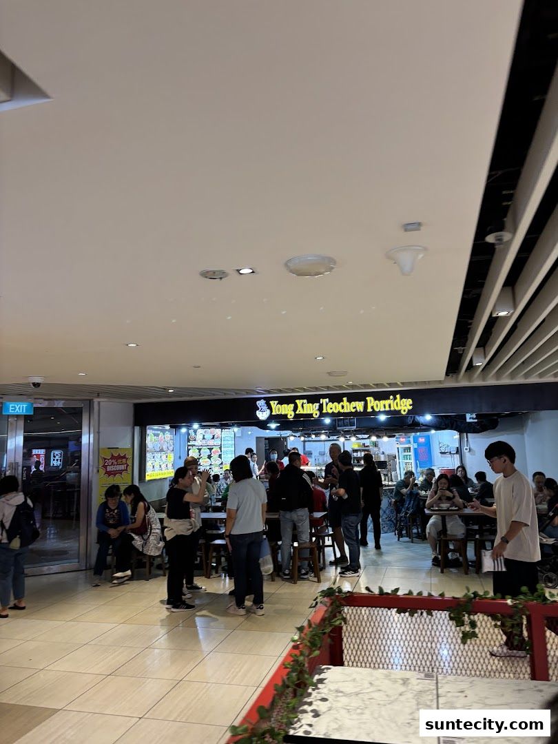 People dining at Yong Xing Teochew Porridge, a busy eatery with a prominent sign.