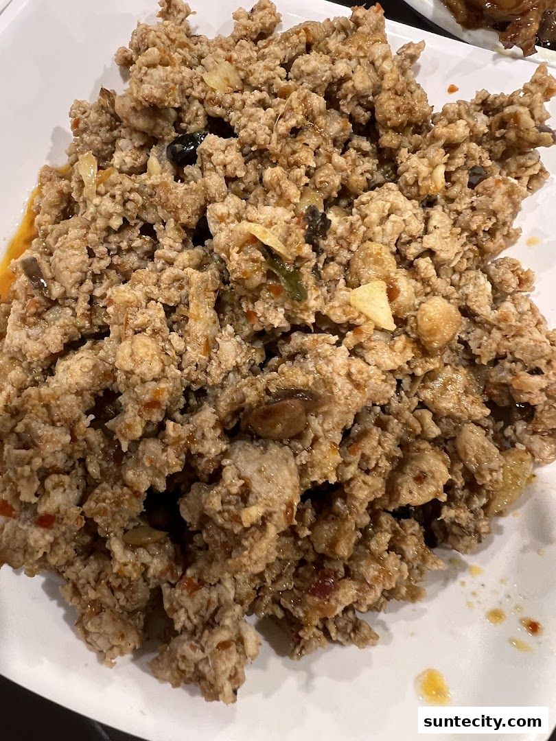 A close-up shot of a plate of minced meat dish with visible spices and ingredients.