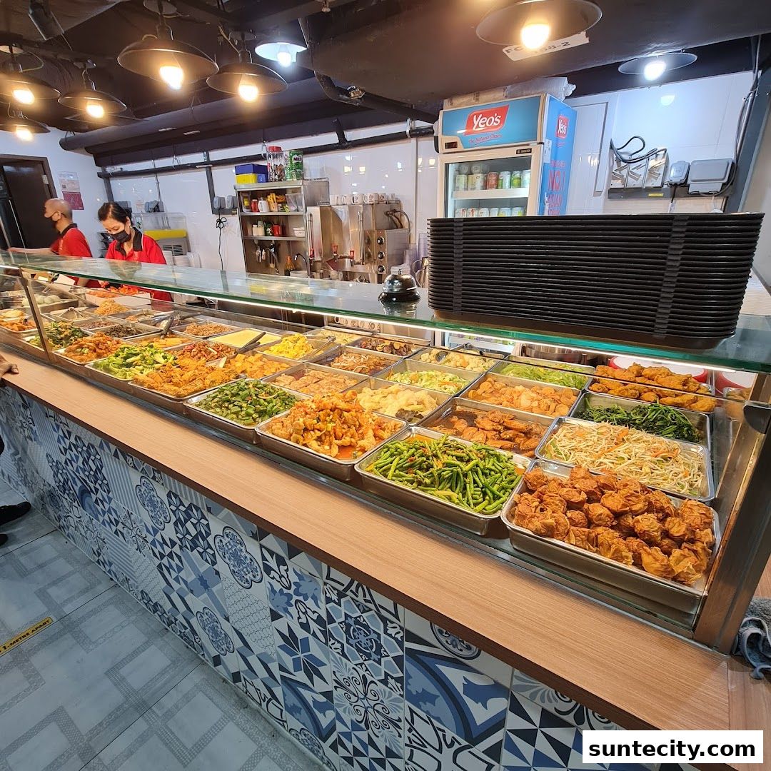 A display counter filled with various Teochew porridge dishes and a stack of black plates.