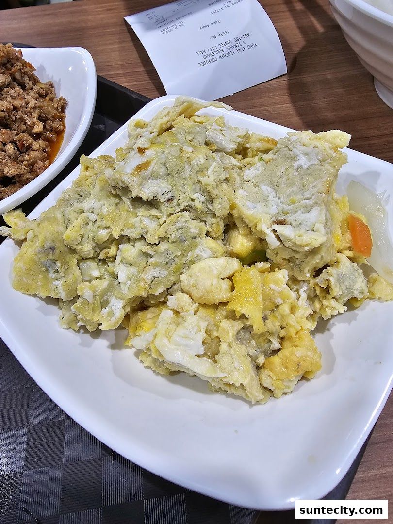A close-up of Teochew porridge with minced meat and scrambled eggs.