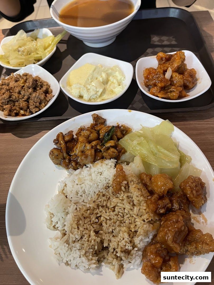 A plate of Teochew porridge with various side dishes and a bowl of soup.