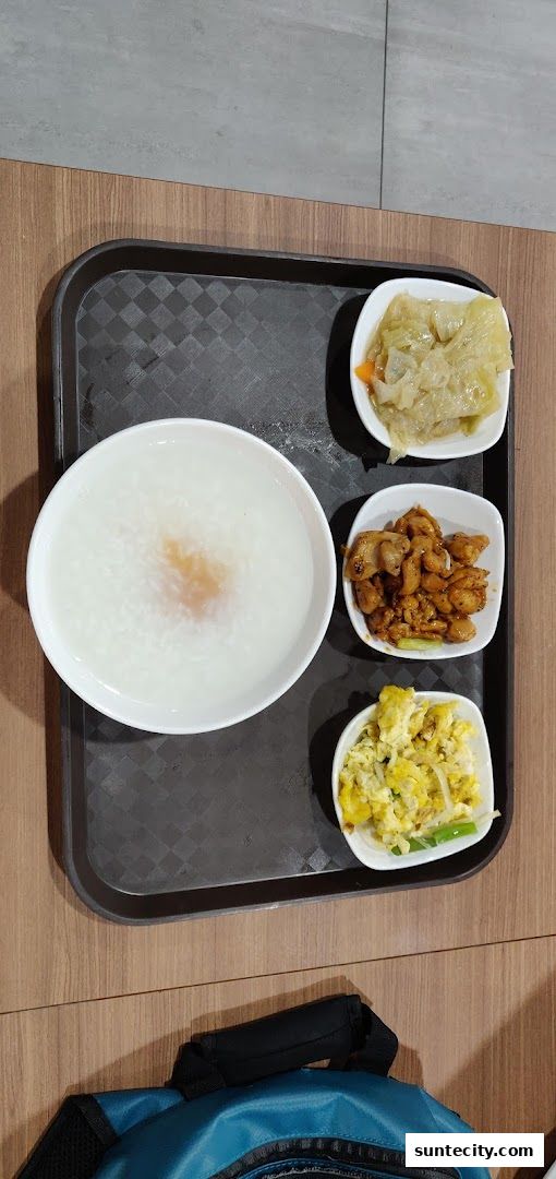A tray of Teochew porridge with three side dishes: braised cabbage, chicken, and scrambled eggs.