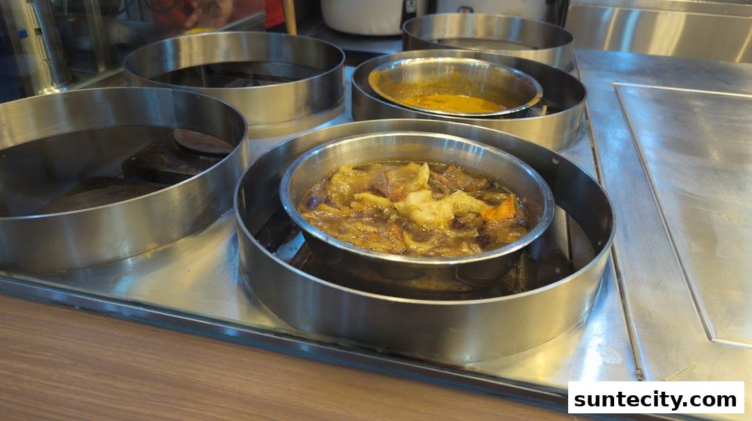 Close-up of stainless steel containers holding various savory dishes, likely for porridge.